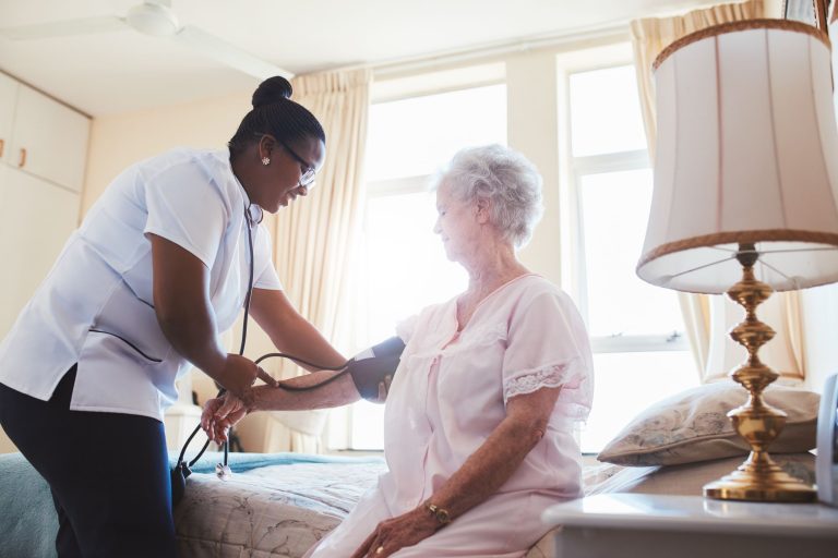 black -caregiver-taking-care-of-a-white-elderly-woman