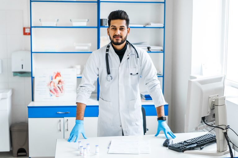 indian-doctor-man-in-a-white-medical-gown-and-a-stethoscope-in-a-hospital